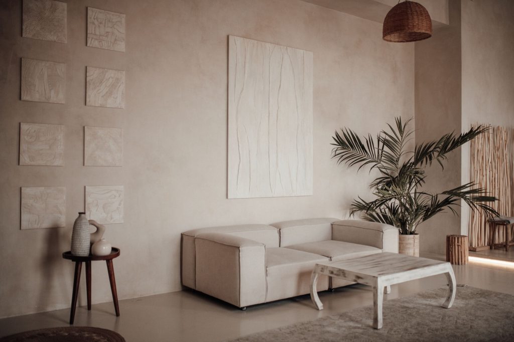 Mur de salon à Douala avec enduit décoratif effet chaux, teinte sable chaud, jeux de lumière