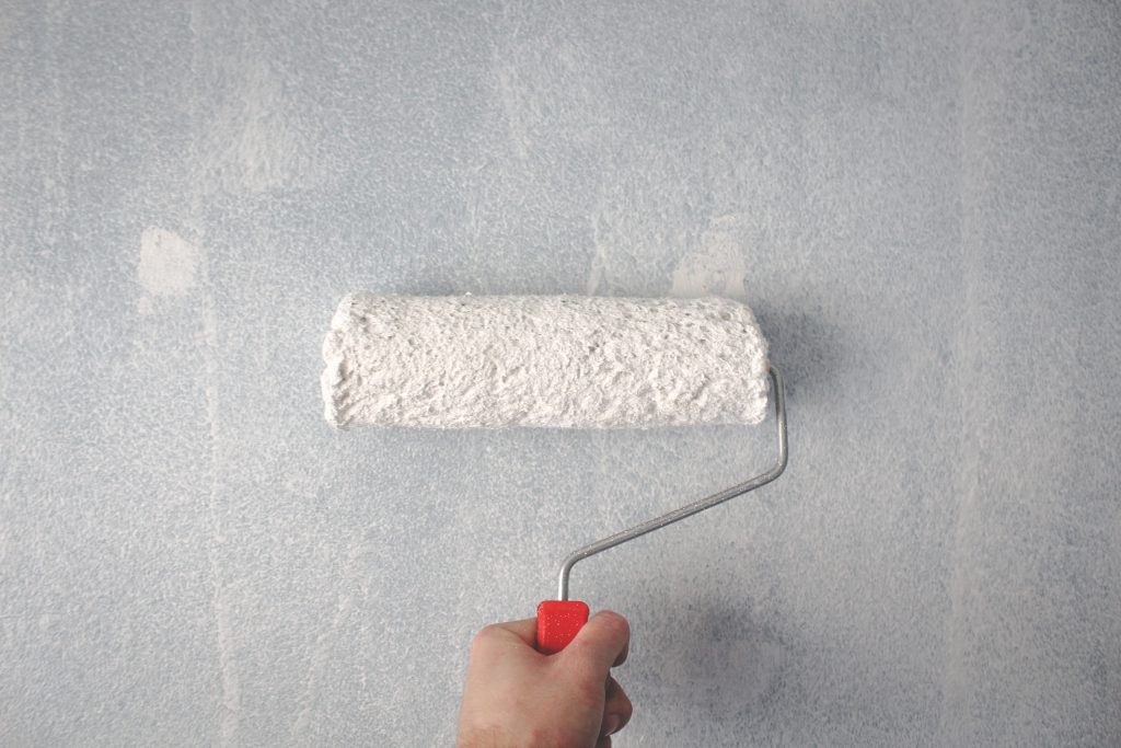 Application d'un primaire anti-humidité sur un mur de salle de bain à Douala avant peinture